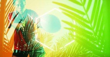 Composite of hexagon and plants over african american female rugby player catching ball. Copy space, nature, shape, sport, competition, playing, match, illuminated and abstract concept.