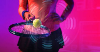 Midsection of biracial female tennis player practicing with racket and ball over circular pattern. Illuminated, copy space, composite, sport, competition, playing, neon, hand, pink, abstract concept.