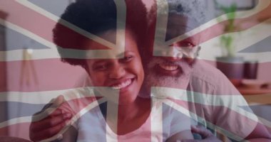 Animation of flag of uk over senior african american father and adult daughter. Politics and patriotism concept digitally generated video.