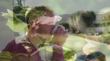 Animation of plants over caucasian man drinking coffee. Gardening, lifestyle and nature concept digitally generated video.