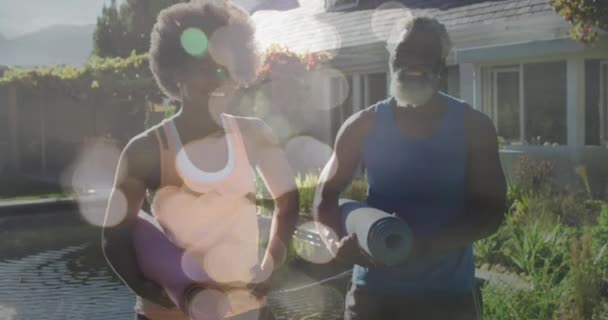 Animering Ljusfläckar Över Afrikanskt Amerikanskt Par Som Håller Yogamatta Slow — Stockvideo