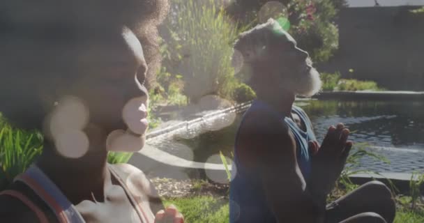 Animation Light Spots African American Couple Doing Yoga Meditating Slow — Vídeos de Stock