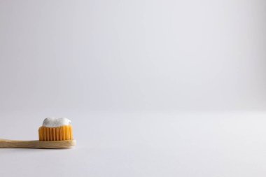 Image of eco toothbrush with toothpaste and copy space on white background. Plastic free beauty, health and beauty, sustainability concept.