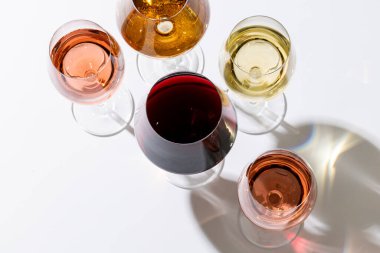Glasses with red, rose and white wine on white background, with copy space. Wine week, drink and celebration concept.