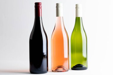 Bottles of red, rose and white wine on white background, with copy space. Wine week, drink and celebration concept.