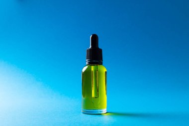 Image of glass bottle with pump and copy space on blue background. Plastic free beauty, health and beauty, sustainability concept.