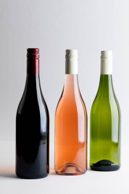 Bottles of red, rose and white wine on white background, with copy space. Wine week, drink and celebration concept.