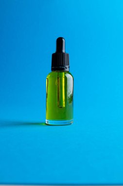Image of glass bottle with pump and copy space on blue background. Plastic free beauty, health and beauty, sustainability concept.