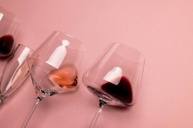 Glasses with red, rose and white wine on pink background, with copy space. Wine week, drink and celebration concept.
