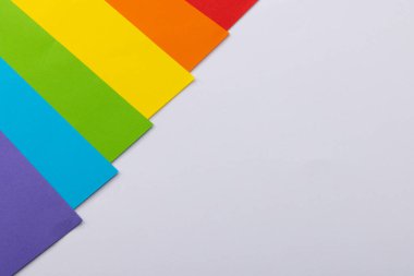 Close up of rainbow coloured cards with copy space on white background. Pride month, equality, lgbt and human rights concept.