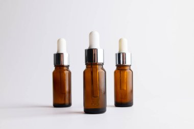 Image of three glass bottles with pumps and copy space on white background. Plastic free beauty, health and beauty, sustainability concept.