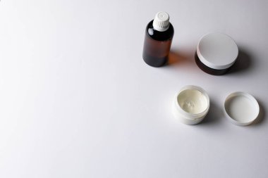 Image of glass bottle and cream tubs with copy space on white background. Plastic free beauty, health and beauty, sustainability concept.