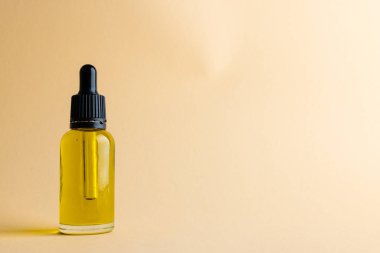 Image of glass bottle with pump and copy space on yellow background. Plastic free beauty, health and beauty, sustainability concept.