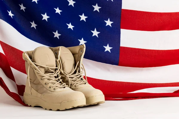 Military boots over flag of usa on white background, with copy space. Memorial day, patriotism and celebration concept.