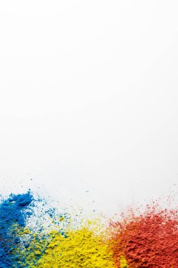 Close up of multi coloured powder and copy space on white background. Holi festival, colour, hindu tradition and celebration concept.