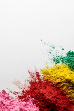 Close up of multi coloured powder and copy space on white background. Holi festival, colour, hindu tradition and celebration concept.