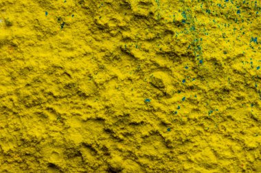 Close up of yellow and green powder background, with copy space. Holi festival, colour, hindu tradition and celebration concept.