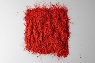 Close up of red powder with copy space on white background. Holi festival, colour, hindu tradition and celebration concept.