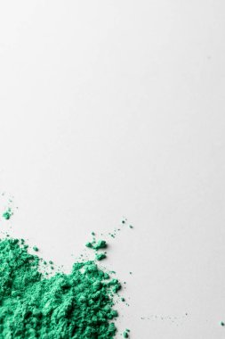 Close up of green powder with copy space on white background. Holi festival, colour, hindu tradition and celebration concept.
