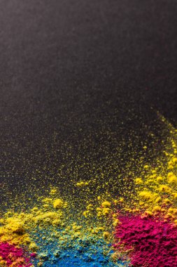 Close up of multi coloured powder and copy space on black background. Holi festival, colour, hindu tradition and celebration concept.