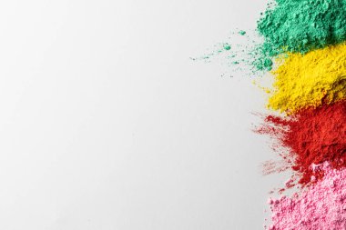 Close up of multi coloured powder and copy space on white background. Holi festival, colour, hindu tradition and celebration concept.