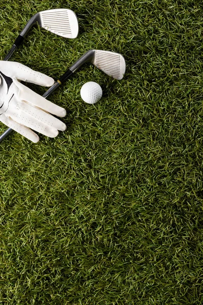 Close up of white glove, golf balls and golf clubs on grass with copy space. Golf, sports and competition concept.