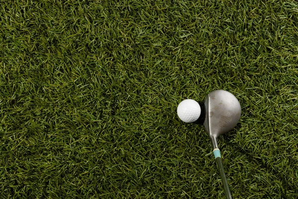 White golf ball and golf club on grass with copy space. Golf, sports and competition concept.