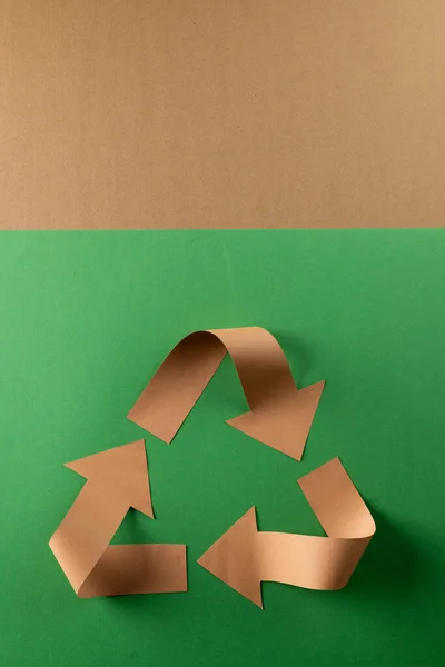 Close up of recycling symbol of paper arrows on green and red background with copy space. Global ecology and recycling concept.
