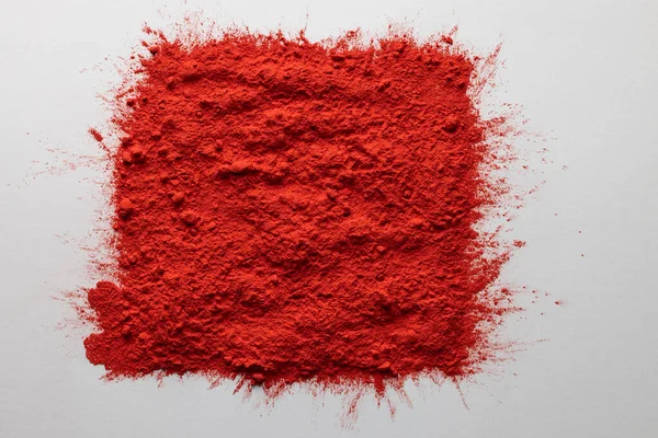 Close up of red powder with copy space on white background. Holi festival, colour, hindu tradition and celebration concept.