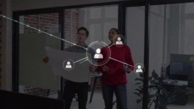 Animation of network of profile icons over diverse man and woman discussing over a plan at office. Global networking and business technology concept