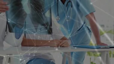 Animation of network of connections over team of doctor examining x-ray report at hospital. Global networking and medical healthcare technology concept