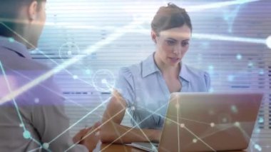 Animation of data processing over caucasian businesswomen using laptop. Global business, finances, computing and data processing concept digitally generated video.