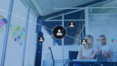 Animation of profile icons connected with lines over diverse coworkers discussing reports on tablet. Digital composite, multiple exposure, office, communication, teamwork and technology concept.