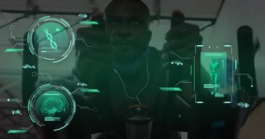 Animation of data processing over african american man on stationary bike in gym. Global sports, science, computing, digital interface and data processing concept digitally generated video.