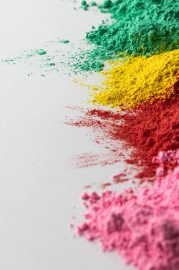 Close up of multi coloured powder and copy space on white background. Holi festival, colour, hindu tradition and celebration concept. 
