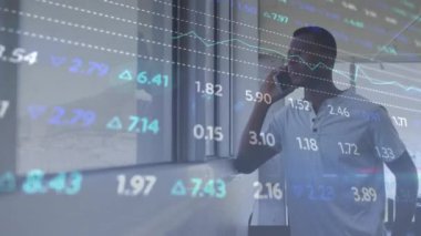 Animation of stock market data processing against african american man talking on smartphone. Global economy and business data technology concept