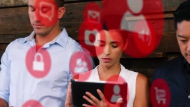 Animation of mobile apps icons in circles over diverse people using digital tablets and cellphones. Digital composite, multiple exposure, social media and wireless technology concept.