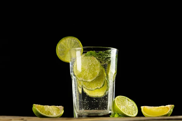 Glas Met Water Limoenen Houten Tafel Met Kopieerruimte Zwarte Ondergrond — Stockfoto