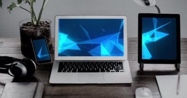 Animation of technological devices with blue shapes on screen on desk. Global technology, abstract background and digital interface concept digitally generated video.