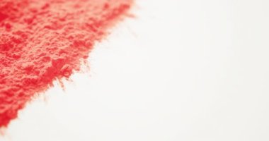 Beyaz zemin üzerinde fotokopi alanı olan kırmızı renkli tozun videosu. Holi festivali, Hint geleneği ve kutlama konsepti
