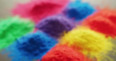 Video of close up of multi coloured powders with copy space on white background. Holi festival, hindu tradition and celebration concept