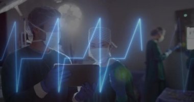 Animation of cardiograph over diverse surgeons using tablet at hospital. Medicine, healthcare and digital interface concept concept digitally generated video.