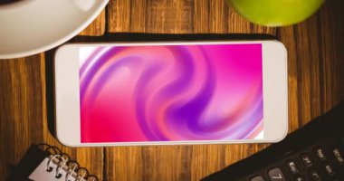 Animation of smartphone with pink moving shapes on screen on wooden desk. Global technology, abstract background and digital interface concept digitally generated video.