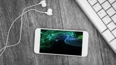 Animation of smartphone with light trails on screen and earphones on desk. Global technology, abstract background and digital interface concept digitally generated video.