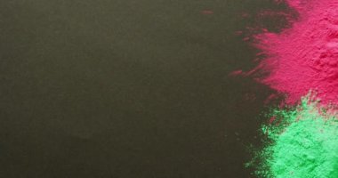 Video of multi coloured powders with copy space on black background. Holi festival, hindu tradition and celebration concept