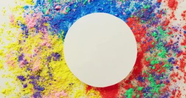 Video of multi coloured powders and white circle with copy space on white background. Holi festival, hindu tradition and celebration concept
