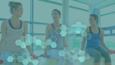 Animation of data processing over diverse women exercising in gym with weights. Global sports, science, computing, digital interface and data processing concept digitally generated video.