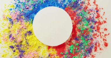 Video of multi coloured powders and white circle with copy space on white background. Holi festival, hindu tradition and celebration concept