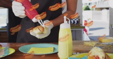 Animation of hot-dog icons over african american woman working in food truck. Food, drink and lifestyle concept concept digitally generated video.
