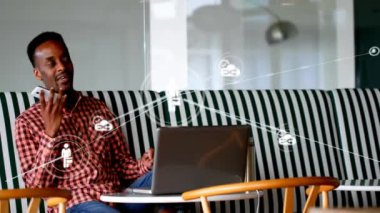 Animation of network of profile icons over african american man talking on smartphone at office. Global networking and business technology concept